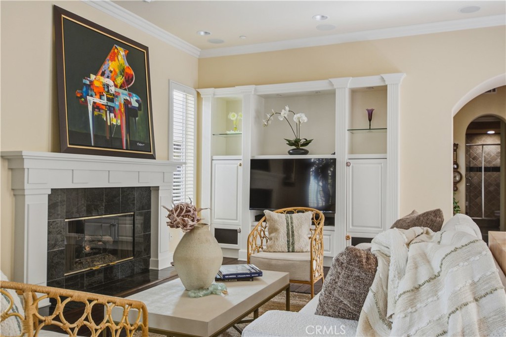 Living room with recessed lighting, crown molding, dark wood flooring, white fireplace, mantle and tile, large window wi - 21322 Balerma, Huntington Beach CA 92648 - photo 12