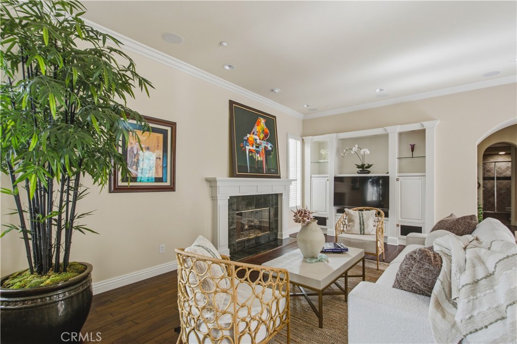 Living room with recessed lighting, crown molding, dark wood flooring, white fireplace, mantle and tile, large window wi - 21322 Balerma, Huntington Beach CA 92648 - photo 13