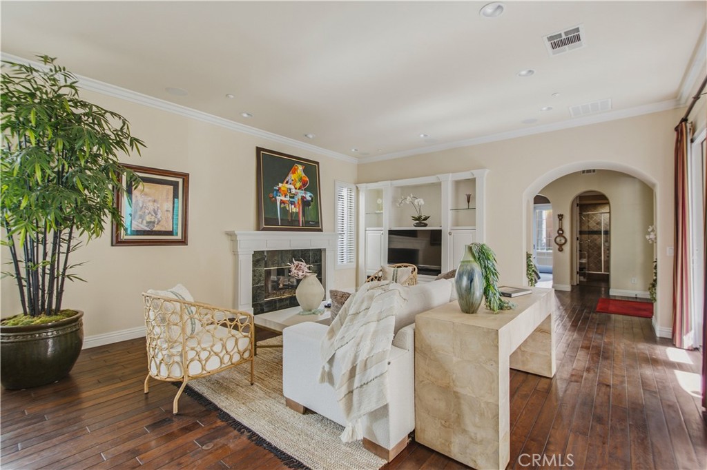 Living room with recessed lighting, crown molding, dark wood flooring, white fireplace, mantle and tile, large window wi - 21322 Balerma, Huntington Beach CA 92648 - photo 14