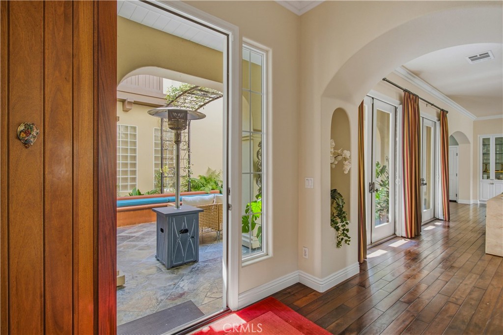 Main floor living room entry with, arched entry way, multiple French doors to courtyard access. - 21322 Balerma, Huntington Beach CA 92648 - photo 15