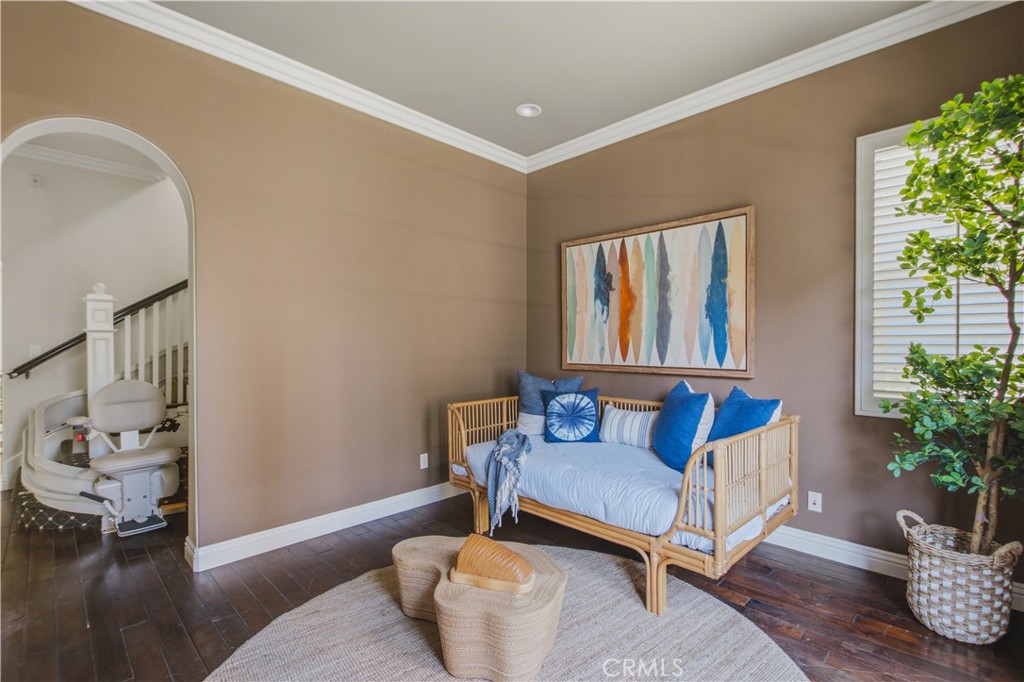 Main floor "bonus" room with dark wood flooring, tray ceilings with crown molding and recessed lighting, plantation shut - 21322 Balerma, Huntington Beach CA 92648 - photo 17