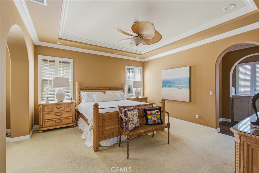 Upper-level Primary bedroom with archway opening into separate sitting area and primary bathroom and plantation shutters - 21322 Balerma, Huntington Beach CA 92648 - photo 21