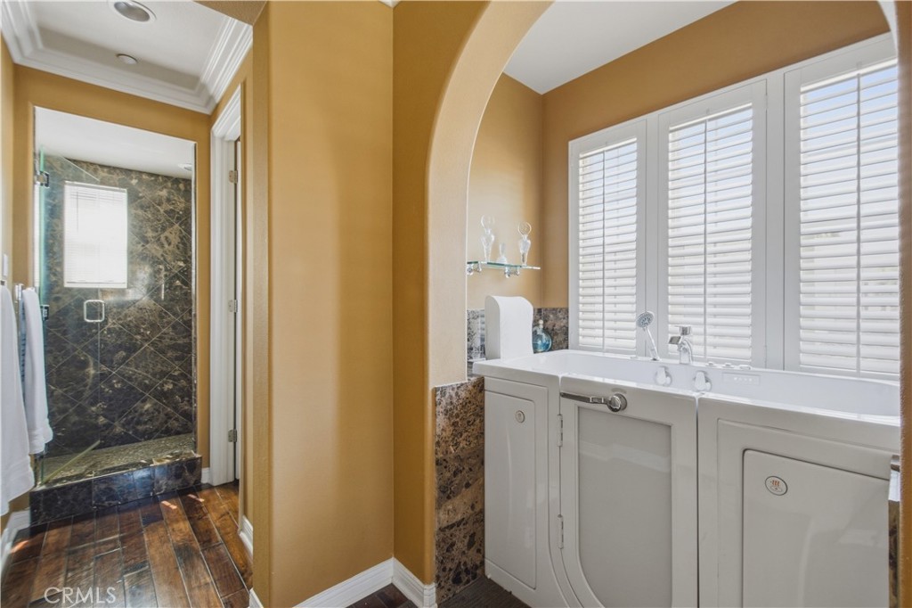 Upper-level Primary ensuite bathroom with walk-in shower with dark stone/tile and glass door enclosure and large jetted - 21322 Balerma, Huntington Beach CA 92648 - photo 23