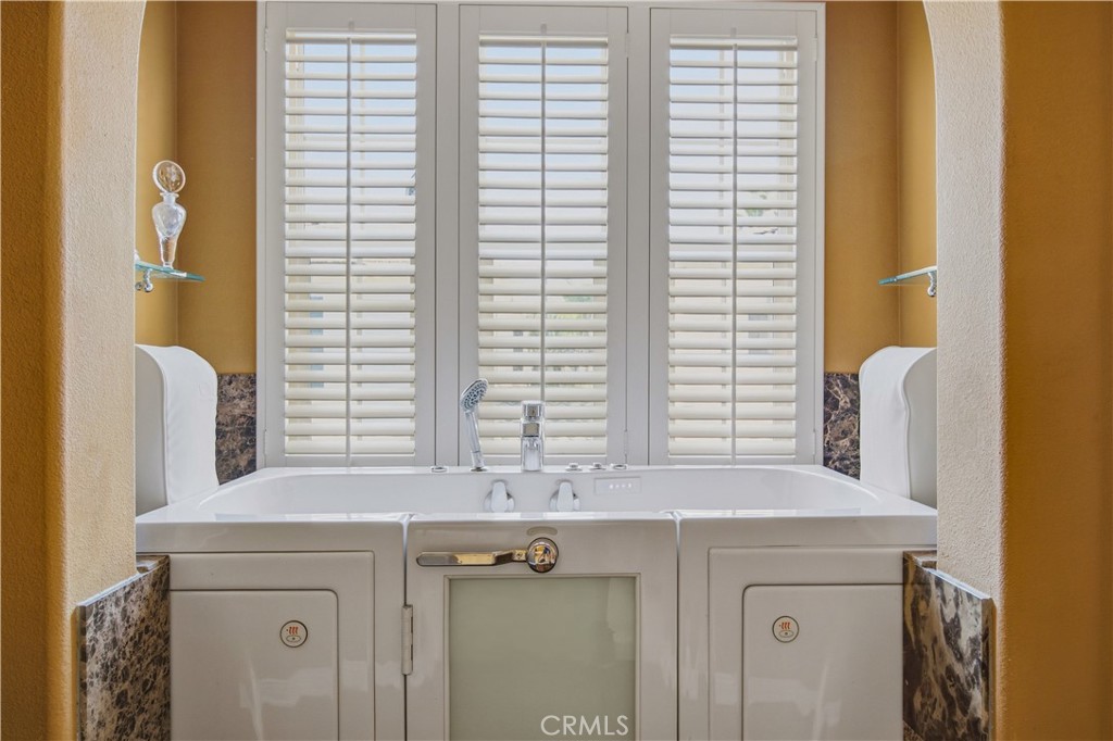 Large jetted soaking tub positioned beneath plantation-shuttered windows - 21322 Balerma, Huntington Beach CA 92648 - photo 24