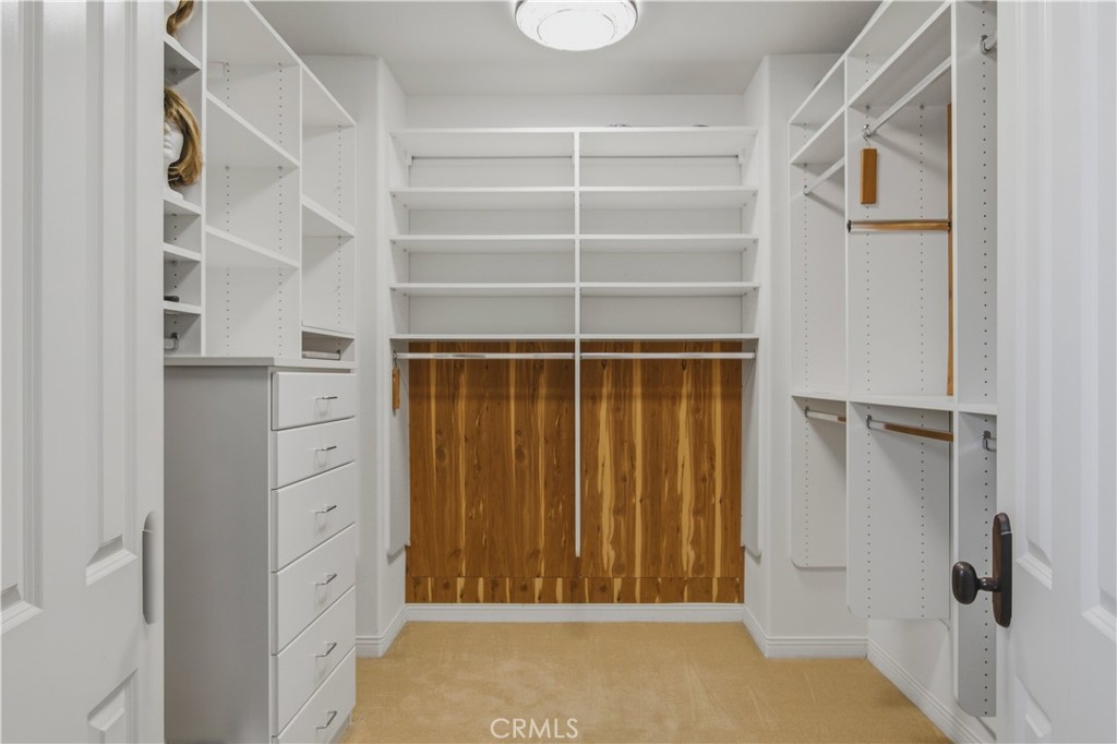 Walk-in closet includes built-in shelving, hanging space, and drawer storage. - 21322 Balerma, Huntington Beach CA 92648 - photo 26