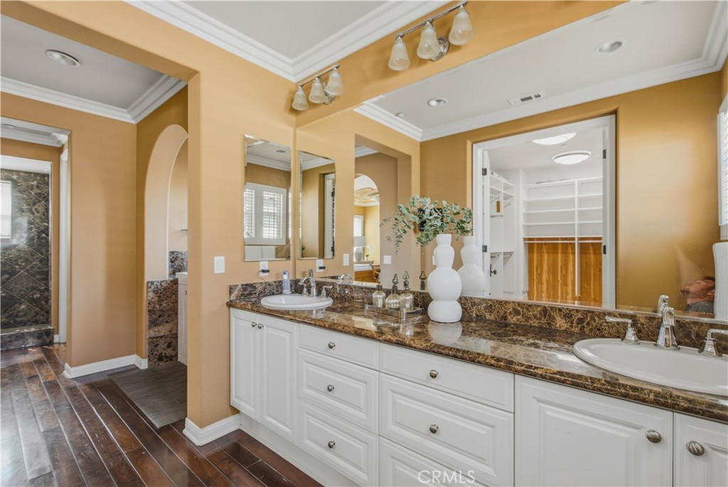 Upper-level Primary dual sink vanity, granite countertops, white cabinetry, expansive mirrors, decorative lighting, crow - 21322 Balerma, Huntington Beach CA 92648 - photo 27