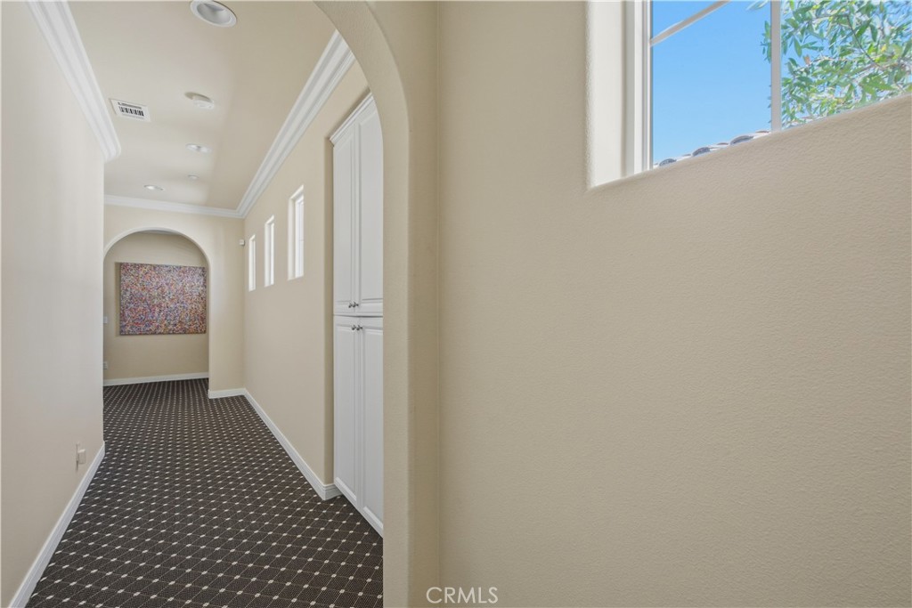 Upper-level hallway with patterned carpet, linen storage, windows with trim, recessed lighting and decorative crown mold - 21322 Balerma, Huntington Beach CA 92648 - photo 30