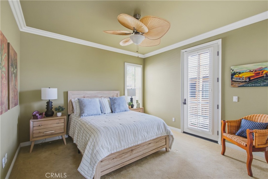 Upper-level 3rd ensuite bedroom with carpet, crown molding, ceiling fan with light, plantation shutters, French style do - 21322 Balerma, Huntington Beach CA 92648 - photo 36