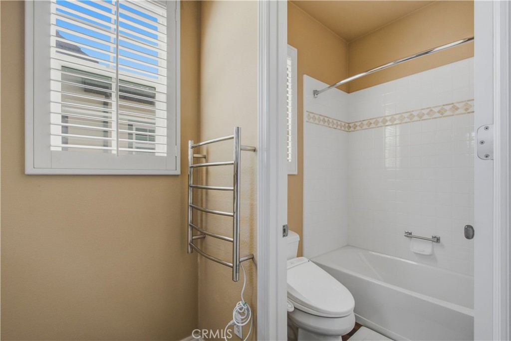 Upper-level 3rd ensuite bathroom with private toilet area, shower in tub and plantation shutters. - 21322 Balerma, Huntington Beach CA 92648 - photo 39