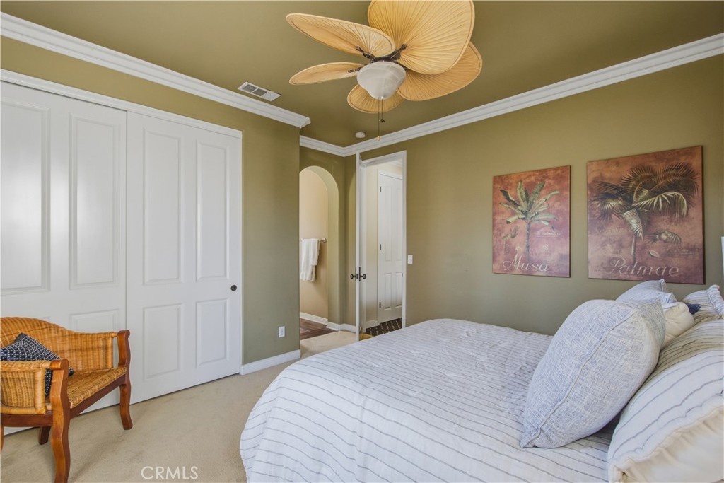 Upper-level 3rd Ensuite bedroom with carpet, crown molding, ceiling fan with light, closet, entry archway into ensuite b - 21322 Balerma, Huntington Beach CA 92648 - photo 40
