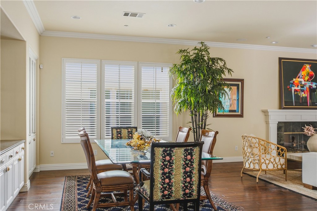 Dining area with dark wood flooring crown molding, recessed lighting, large windows with plantation shutters and space o - 21322 Balerma, Huntington Beach CA 92648 - photo 44