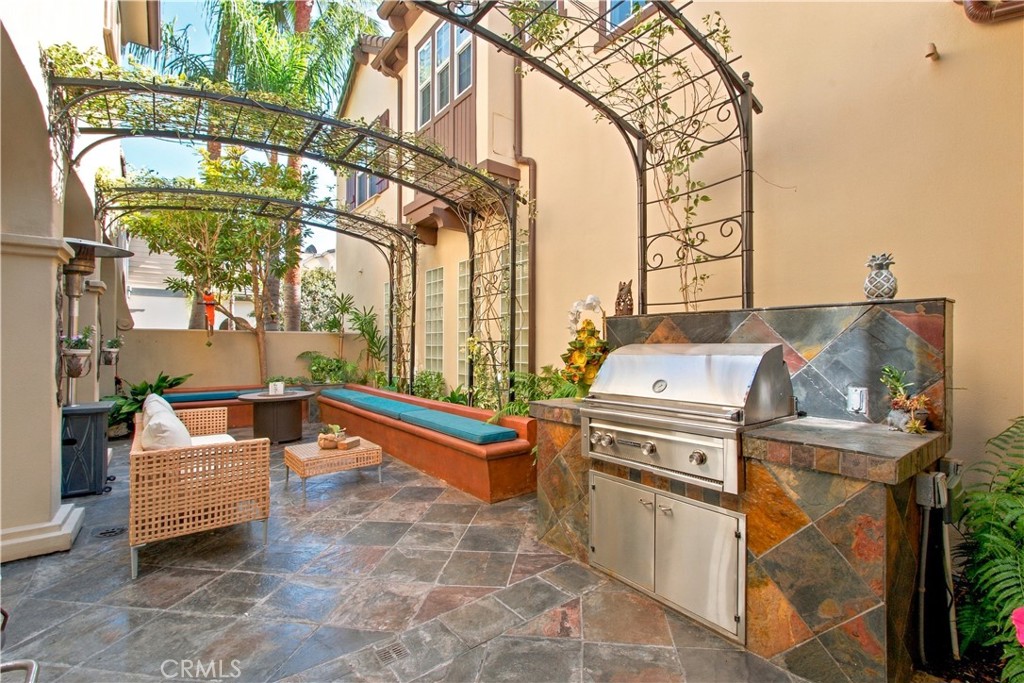 Enclosed courtyard with stone tile flooring, metal trellises with climbing vines, built in seating and custom built outd - 21322 Balerma, Huntington Beach CA 92648 - photo 45