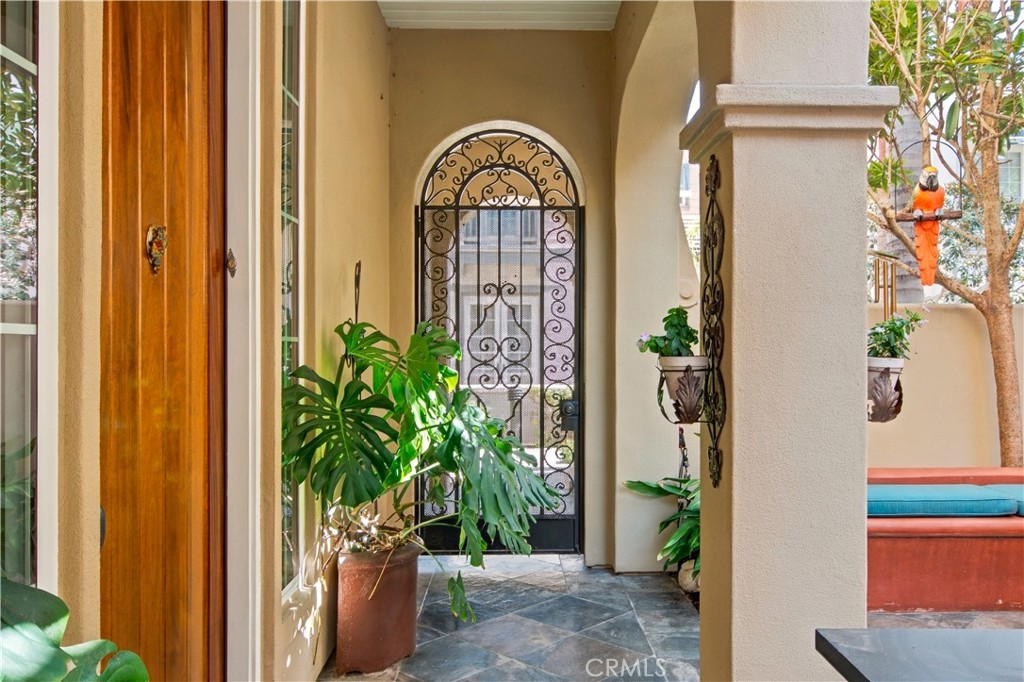 Covered courtyard walkway with ornate arched wrought iron gate. - 21322 Balerma, Huntington Beach CA 92648 - photo 49