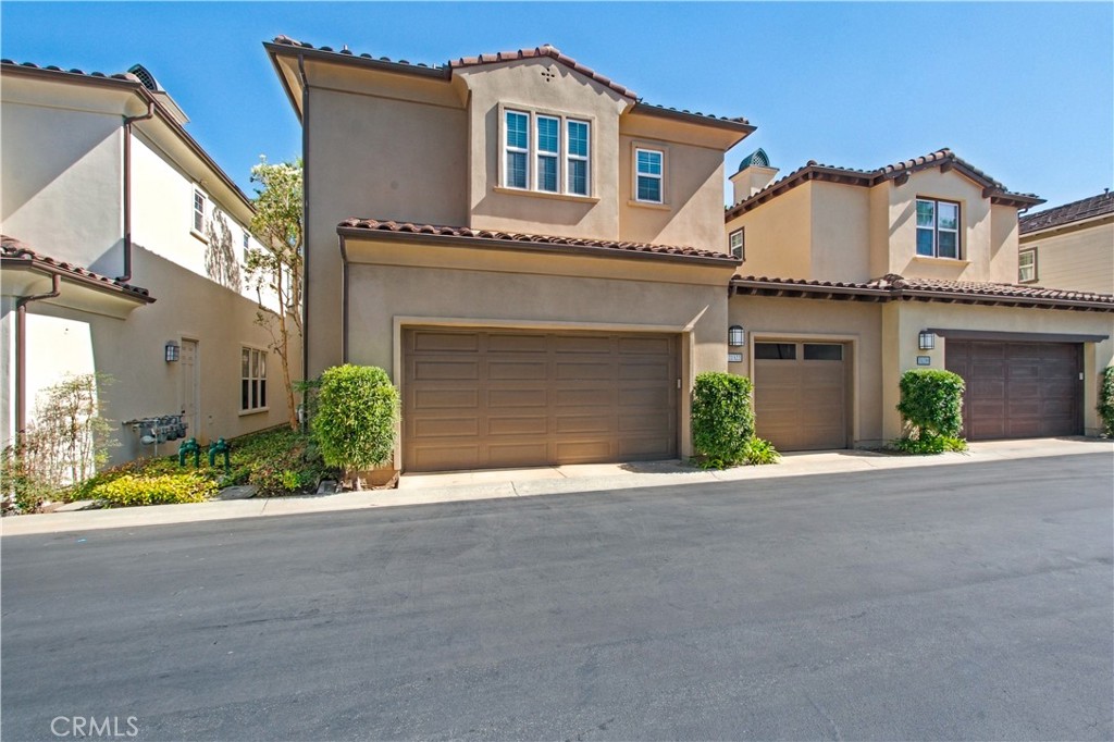 Rear of home including 2-car garage door and single car garage door. - 21322 Balerma, Huntington Beach CA 92648 - photo 55