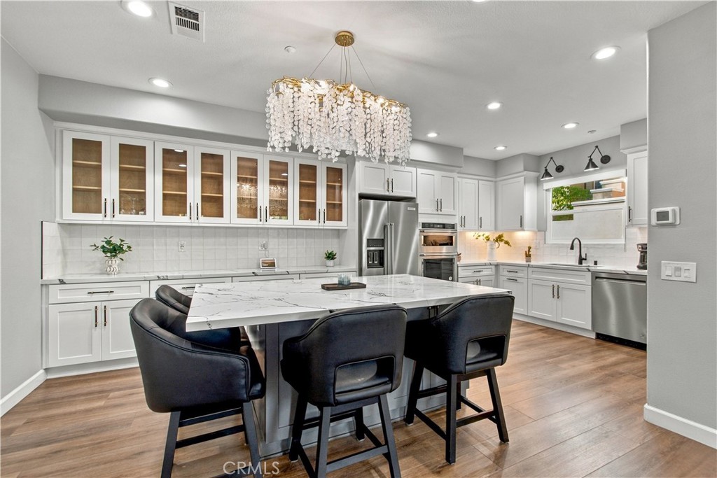 Additional highlights include gorgeous marble-look quartz counters, textured white tile backsplash, white cabinetry acce - 21335 Cieza, Huntington Beach CA 92648 - photo 17