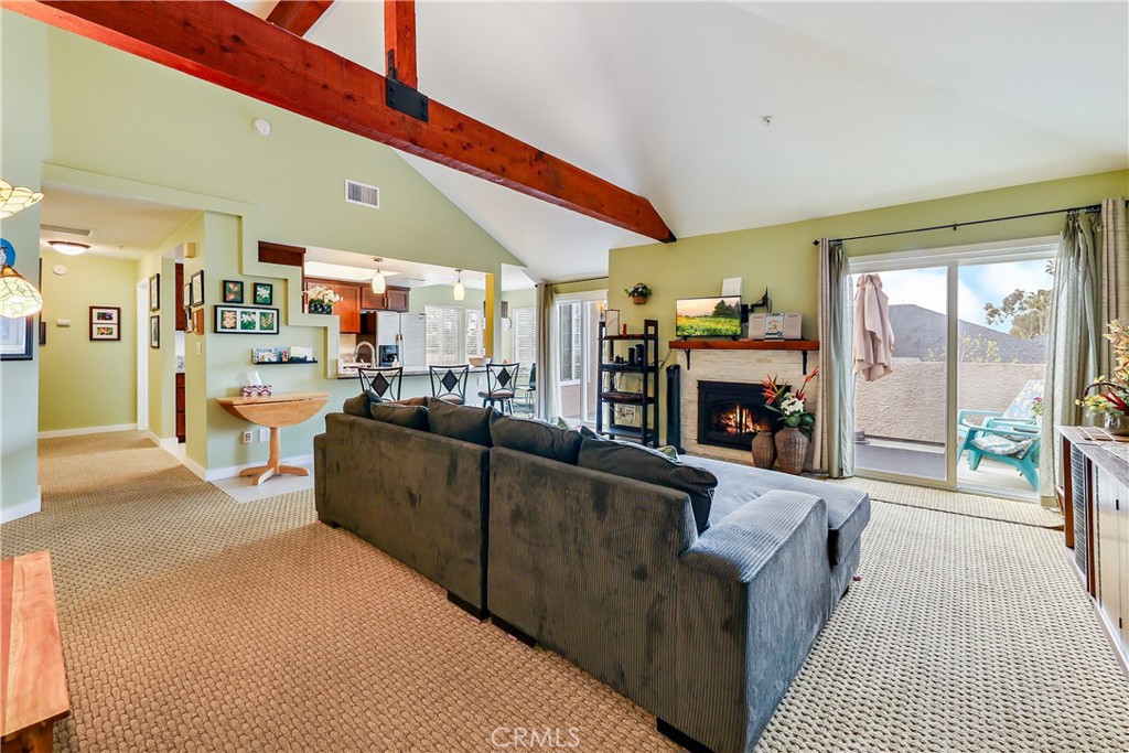 Light and cheery living room with view of outdoor deck and cozy fireplace - 4561 Warner 302, Huntington Beach CA 92649 - photo 1