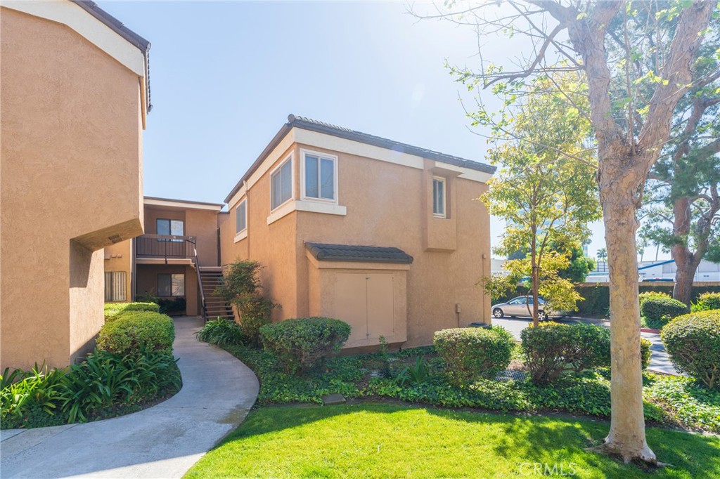 Nestled among greenbelts and trees, unit is upstairs and private. - 7911 Woodlake Drive 77, Huntington Beach CA 92647 - photo 1