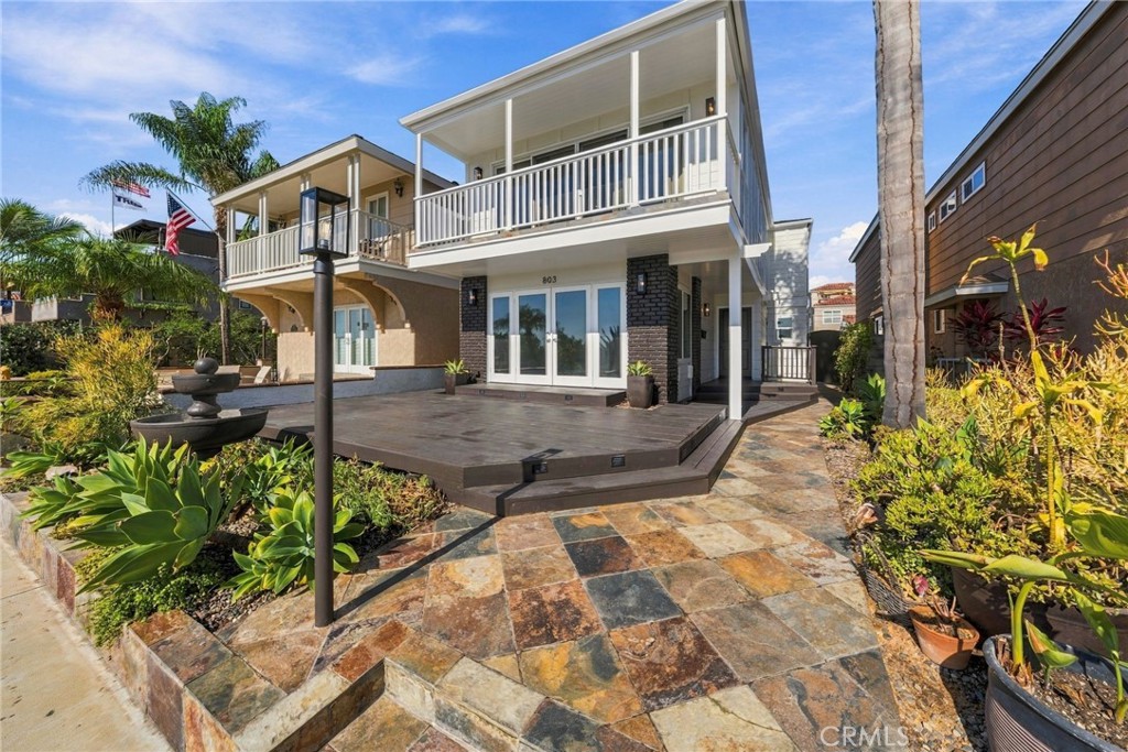 Angled exterior view highlights the front deck, upper balcony, and inviting outdoor living spaces. - 803 Frankfort Avenue, Huntington Beach CA 92648 - photo 3