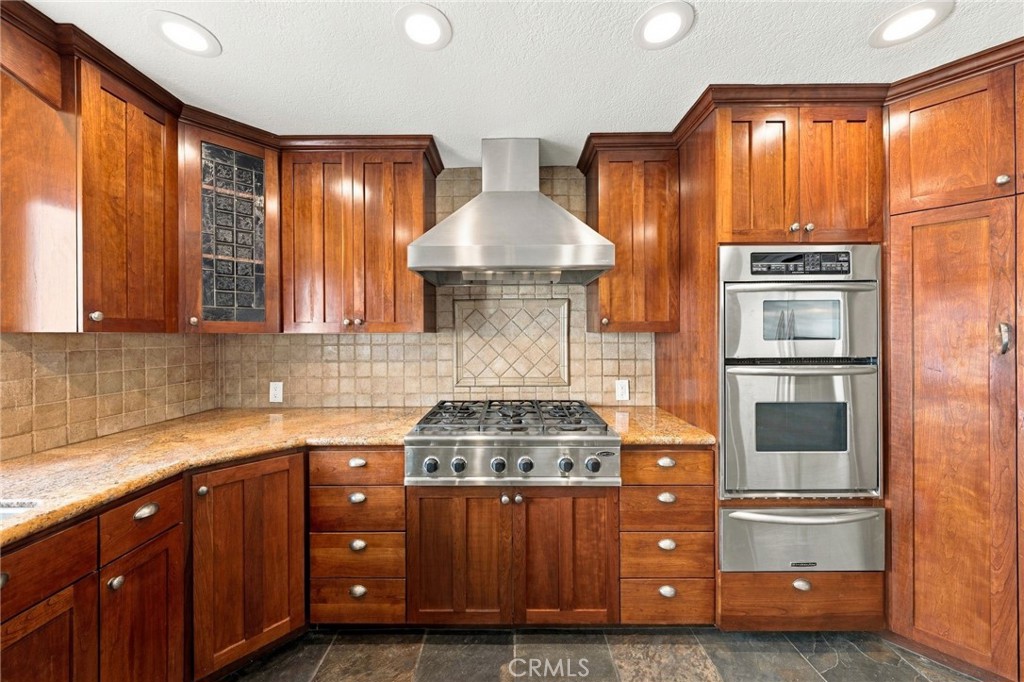 Stainless steel appliances include a 6-burner gas range with vent hood, built-in refrigerator, wall oven, and microwave. - 803 Frankfort Avenue, Huntington Beach CA 92648 - photo 19