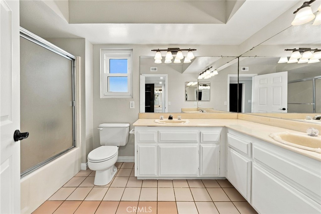 En-suite primary bathroom features dual vanity sinks, tile flooring, and generous counter space. LOTS of potential! - 803 Frankfort Avenue, Huntington Beach CA 92648 - photo 36