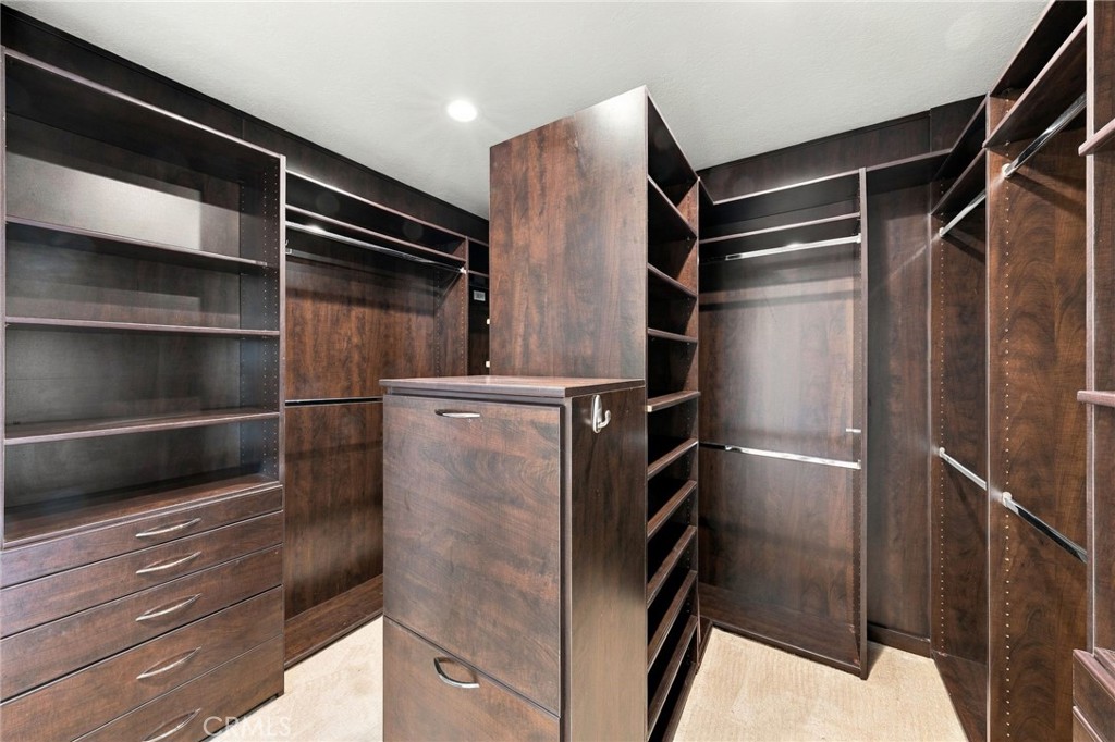 Large walk-in primary closet offers extensive built-in shelving, drawers, and hanging space. - 803 Frankfort Avenue, Huntington Beach CA 92648 - photo 38