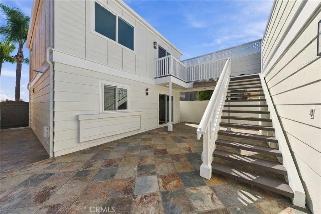 Private rear courtyard begins with tiled hardscape and exterior stairs leading to the upper deck. Think ADU access! - 803 Frankfort Avenue, Huntington Beach CA 92648 - photo 52