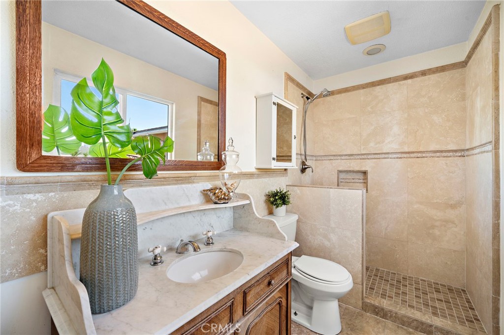 primary bathroom includes a marble-top vanity and walk in shower - 8142 Blaylock Drive, Huntington Beach CA 92647 - photo 20