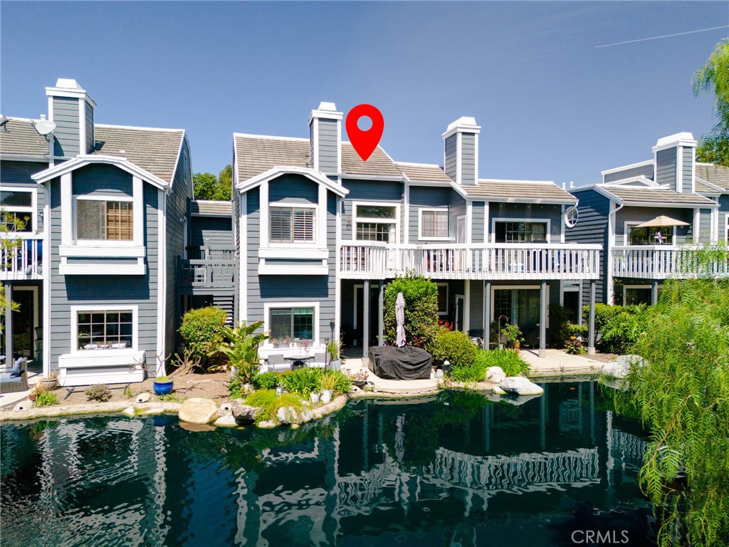 A view of the back of the home, you can see the lovely pond that is enjoyed from the balcony. - 8192 Sandcove 204, Huntington Beach CA 92646 - photo 1
