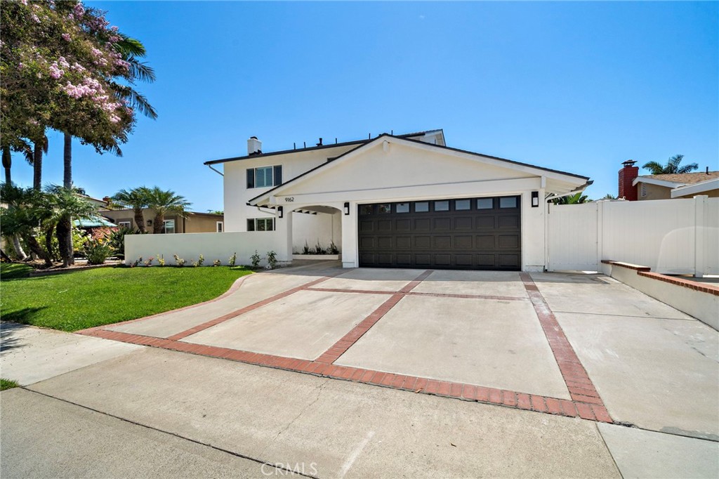 Spacious driveway leads to the attached two-car garage and welcoming covered entrance. - 9162 Brabham Drive, Huntington Beach CA 92646 - photo 3