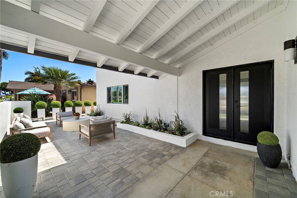 Covered front patio offers a stylish outdoor seating area beside the double-door entry. - 9162 Brabham Drive, Huntington Beach CA 92646 - photo 4