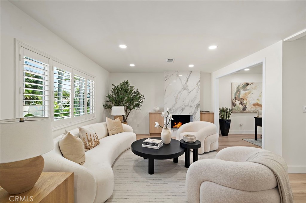Sun-filled living room offers generous seating space and updated dual-pane windows with plantation shutters. - 9162 Brabham Drive, Huntington Beach CA 92646 - photo 7