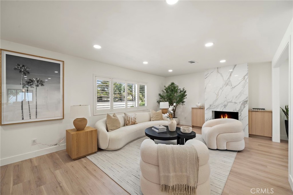 Elegant living room is beautifully finished with recessed lighting, soft neutral tones and wide-plank wood-look flooring - 9162 Brabham Drive, Huntington Beach CA 92646 - photo 8