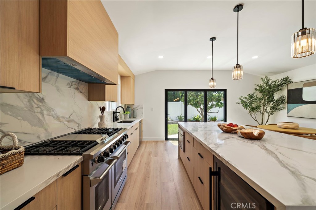Chef-inspired cooking area features a six-burner range, designer backsplash and warm soft-close cabinetry. - 9162 Brabham Drive, Huntington Beach CA 92646 - photo 27