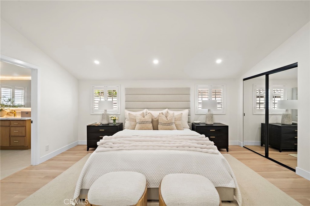 Spacious main-level primary bedroom offers recessed lighting, wood-look flooring and a peaceful contemporary design. - 9162 Brabham Drive, Huntington Beach CA 92646 - photo 30