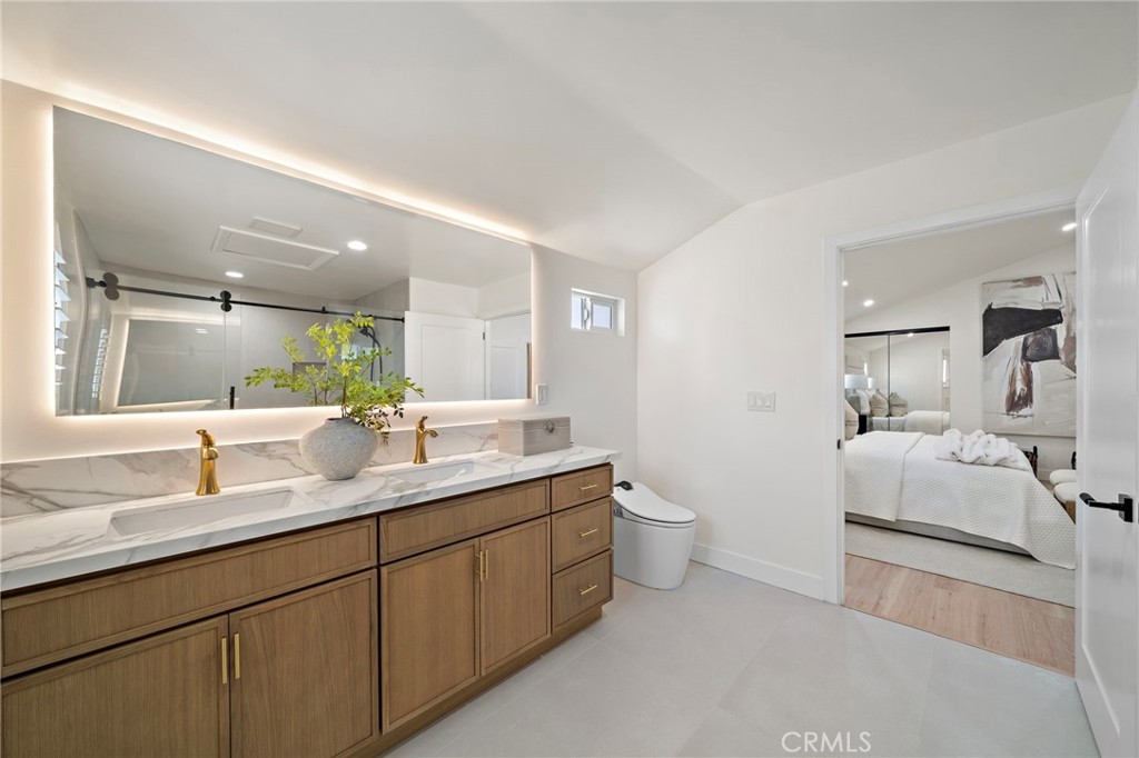 Refined primary bathroom showcases quartz and stone surfaces with modern fixtures and abundant vanity storage. - 9162 Brabham Drive, Huntington Beach CA 92646 - photo 34