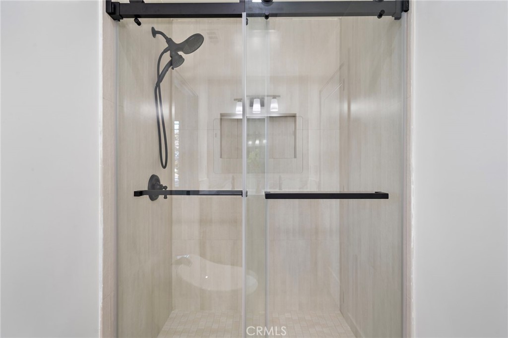 Glass-enclosed shower is finished with elegant designer tile and contemporary black hardware. - 9162 Brabham Drive, Huntington Beach CA 92646 - photo 39