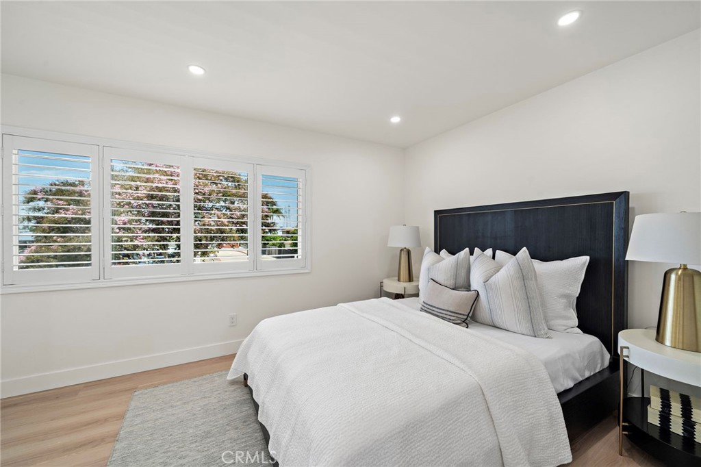 Spacious upstairs bedroom offers recessed lighting, wood-look flooring and a calm neutral palette. - 9162 Brabham Drive, Huntington Beach CA 92646 - photo 40