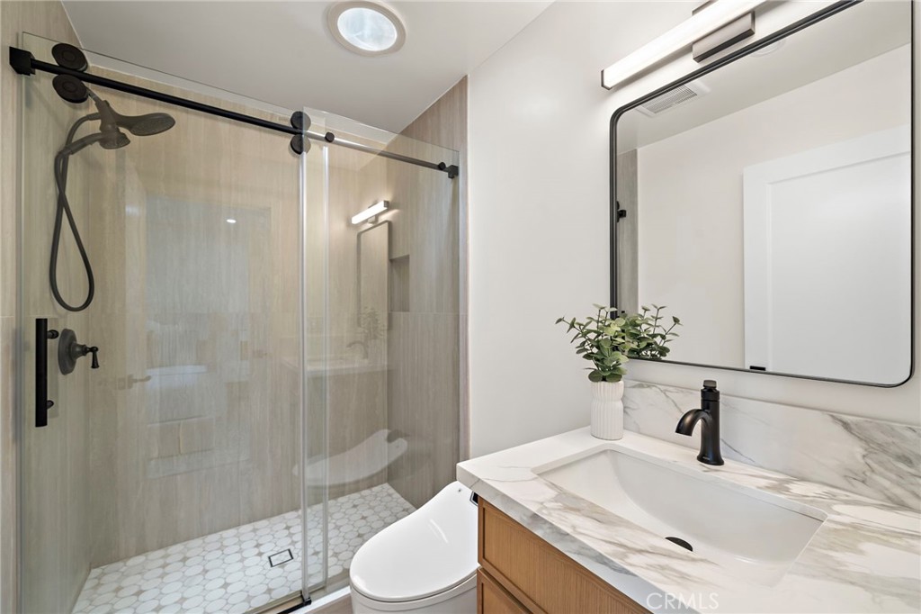 Stylishly updated bathroom features a glass-enclosed shower, modern vanity and refined fixtures. - 9162 Brabham Drive, Huntington Beach CA 92646 - photo 44