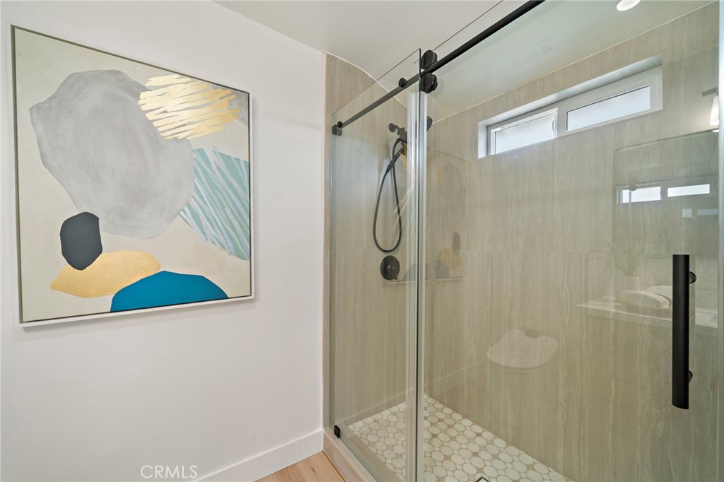 Oversized glass-enclosed shower is beautifully finished with designer tile and sleek black hardware. - 9162 Brabham Drive, Huntington Beach CA 92646 - photo 48