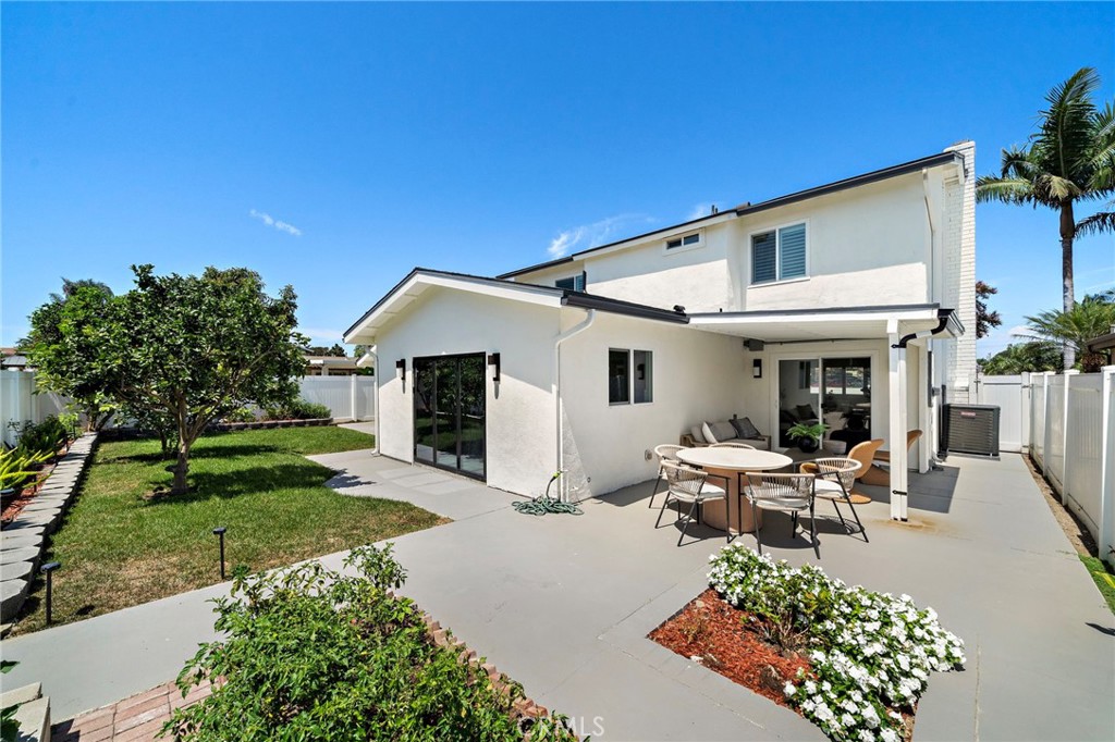 Rear exterior view showcases the home's extensive patio areas and easy indoor-outdoor connection. - 9162 Brabham Drive, Huntington Beach CA 92646 - photo 51