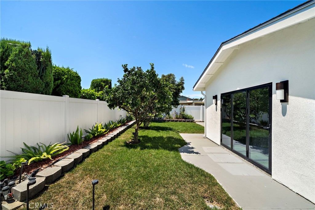 Long side yard combines a paved walkway with lawn and mature greenery. - 9162 Brabham Drive, Huntington Beach CA 92646 - photo 53