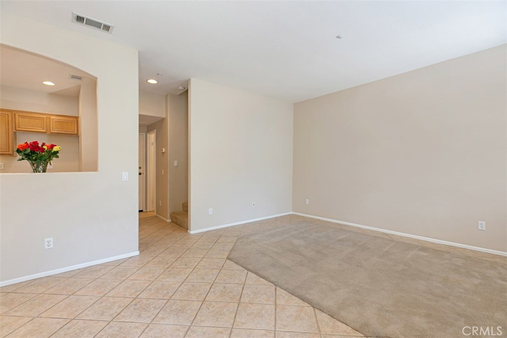 Downstairs common area. Living room and dining space. *flooring to be updated with LVP prior to move-in. - 10 New Market, Irvine CA 92602 - photo 6