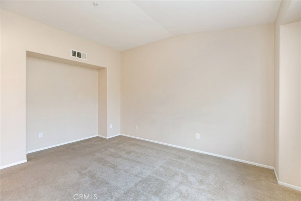 Master bedroom with vaulted ceiling and media/dresser niche. *flooring to be updated with LVP prior to move-in. - 10 New Market, Irvine CA 92602 - photo 9
