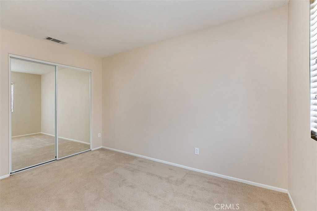 Third bedroom, with mirrored closet and wood-blind shades. *flooring to be updated with LVP prior to move-in. - 10 New Market, Irvine CA 92602 - photo 13