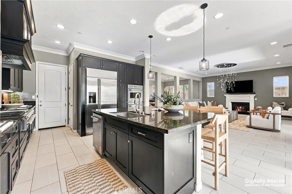 A gourmet kitchen appointed with premium appliances, abundant cabinetry, an oversized center island, and seamless access - 104 Sparrow, Irvine CA 92618 - photo 7