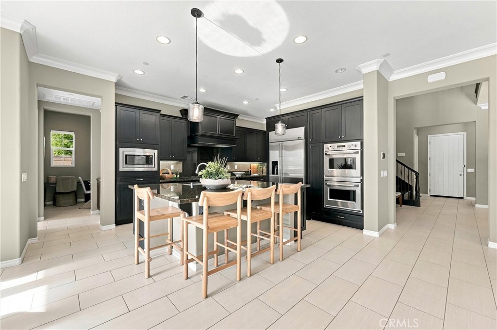 A gourmet kitchen appointed with premium appliances, abundant cabinetry, an oversized center island, and seamless access - 104 Sparrow, Irvine CA 92618 - photo 8