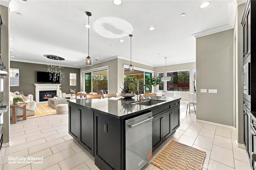 A gourmet kitchen appointed with premium appliances, abundant cabinetry, an oversized center island, and seamless access - 104 Sparrow, Irvine CA 92618 - photo 9