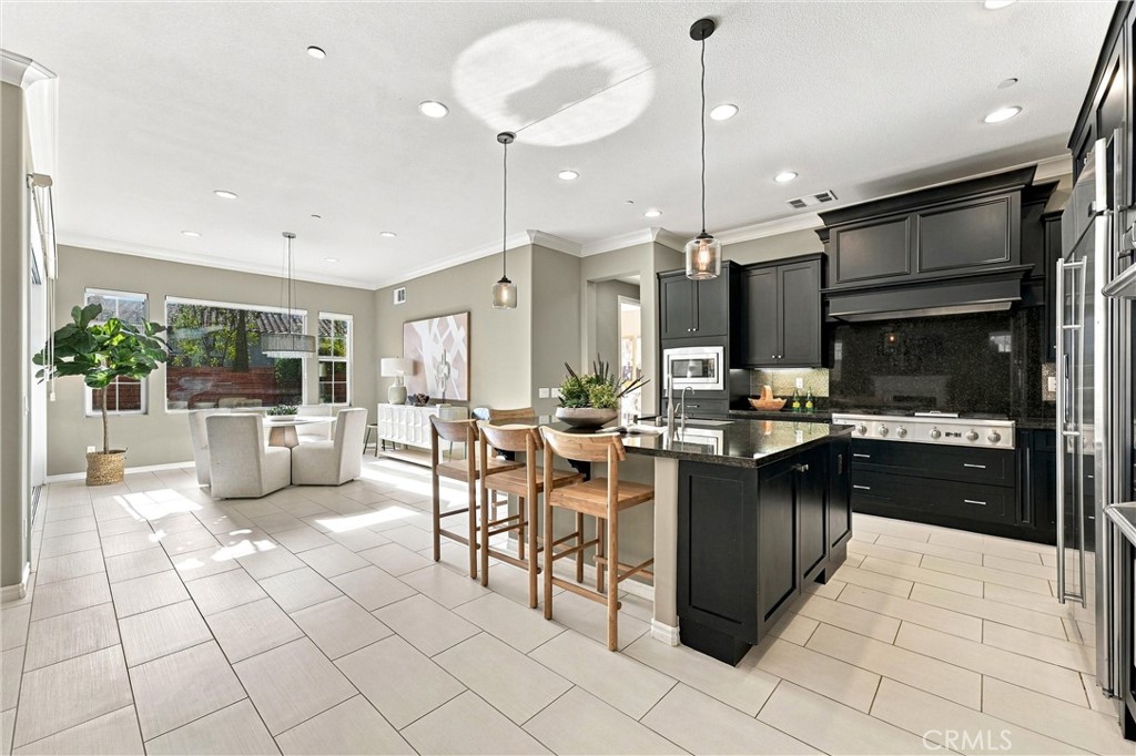 A gourmet kitchen appointed with premium appliances, abundant cabinetry, an oversized center island, and seamless access - 104 Sparrow, Irvine CA 92618 - photo 11