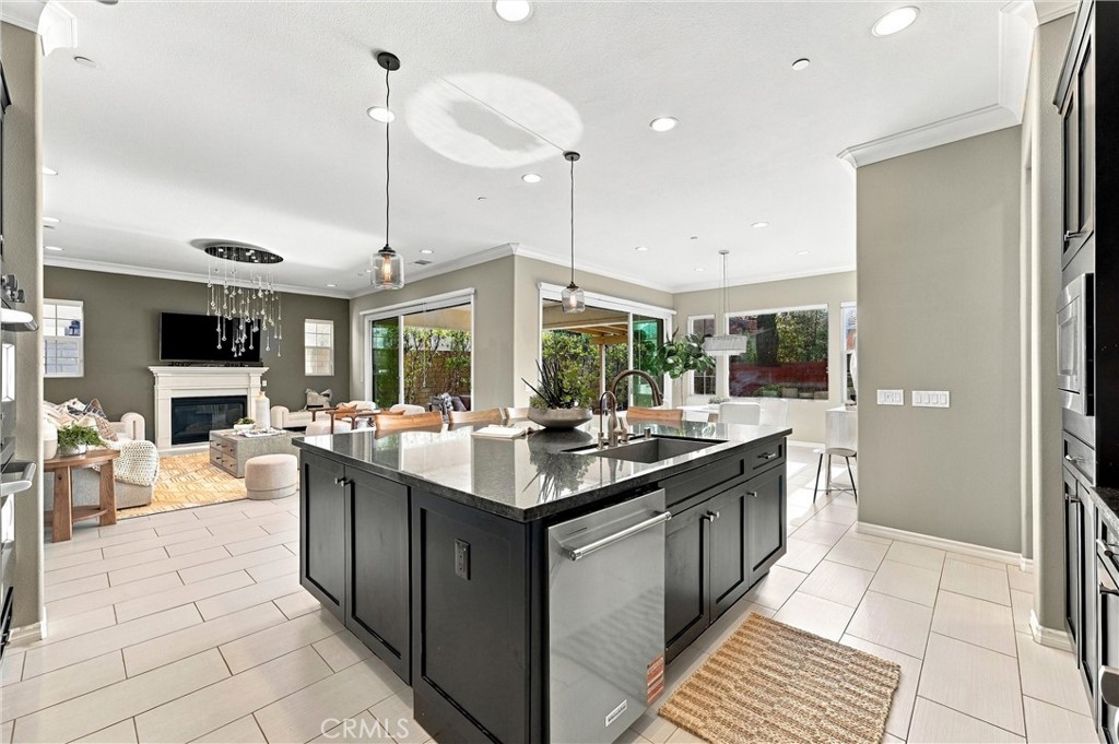 A gourmet kitchen appointed with premium appliances, abundant cabinetry, an oversized center island, and seamless access - 104 Sparrow, Irvine CA 92618 - photo 12