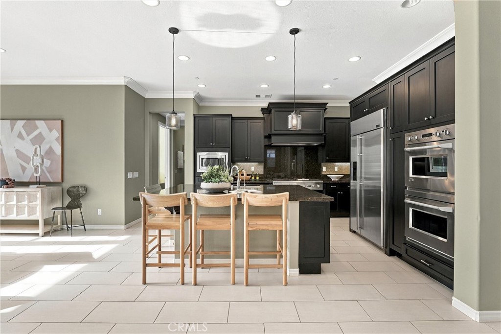 A gourmet kitchen appointed with premium appliances, abundant cabinetry, an oversized center island, and seamless access - 104 Sparrow, Irvine CA 92618 - photo 13
